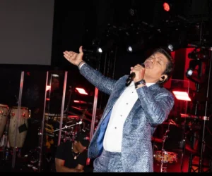 A man singing on stage with a microphone in concert_BlvdChangi
