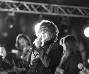 An artist with his band singing on stage with a microphone_BlvdChangi